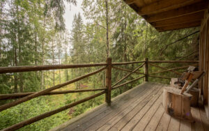 View of the forest from the wooden porch of the treehouse at Naturbyn in Sweden
